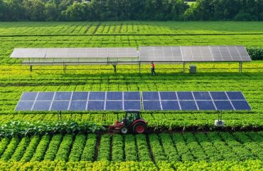 A vibrant agricultural scene showcasing solar panels mounted on farm equipment, emphasizing the integration of solar energy into modern farming with flourishing crops and working farmers.