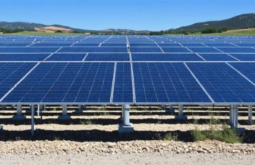 A panoramic view of a 1-megawatt solar power plant with neatly arranged solar panels under a cloudless sky, embodying efficient energy production and environmental stewardship.