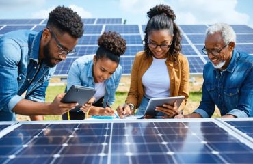 Diverse group of community members collaboratively participating in a solar panel installation workshop, highlighting the educational process and community empowerment through solar energy.